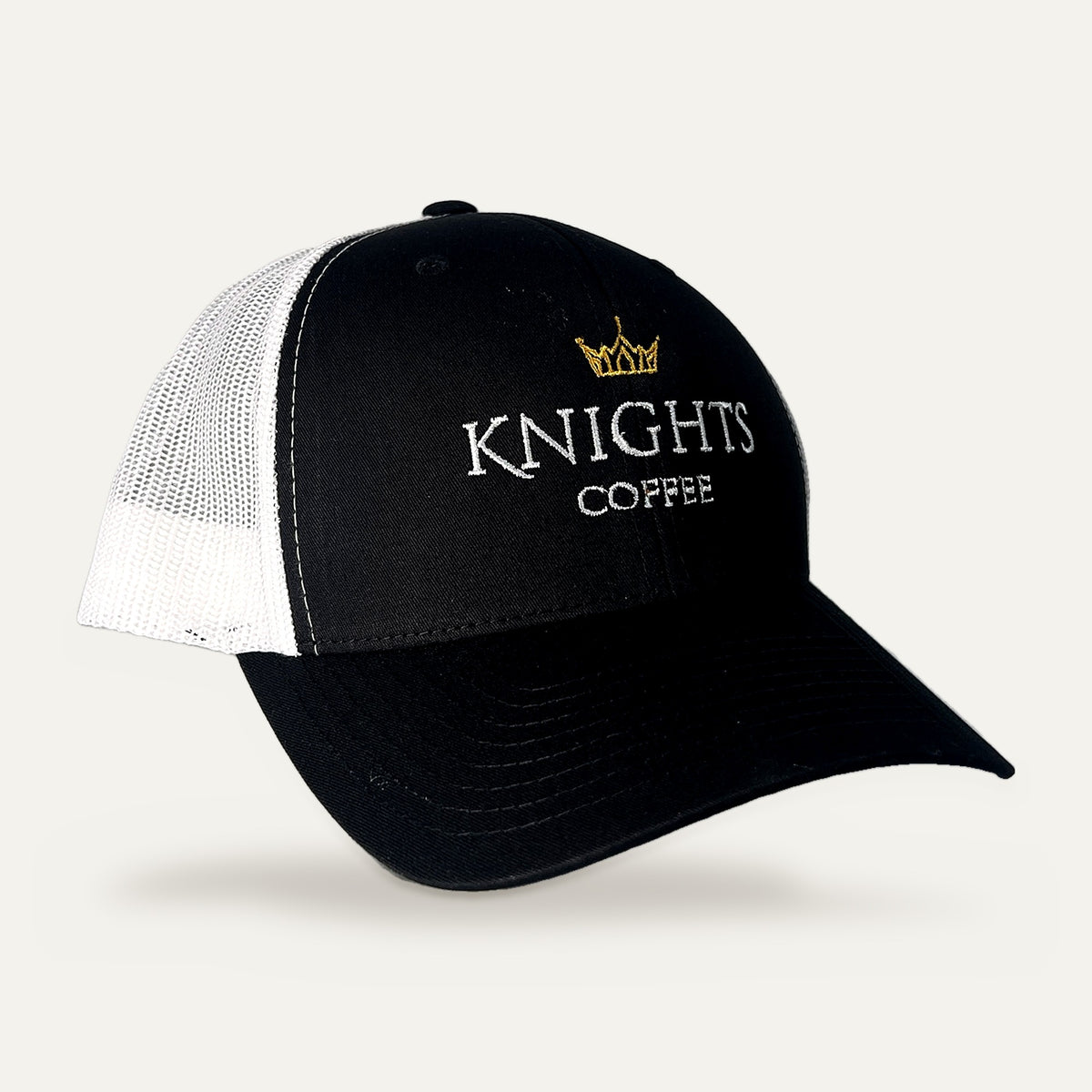 Knights Coffee trucker hat with black front, white mesh back and gold crown embroidery